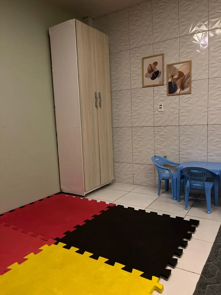 Sala infantil da Reconectar com tapete colorido e mesinha para atendimento de crianças
